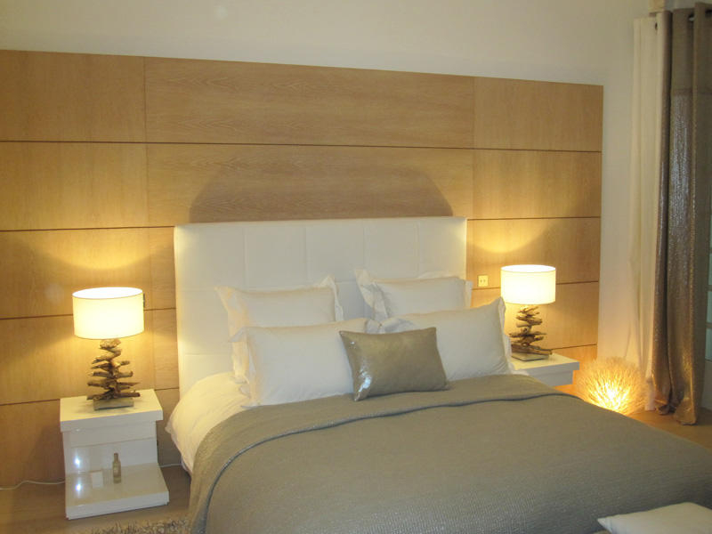 Chambre avec tête de lit habillée de bois et lampes de chevet