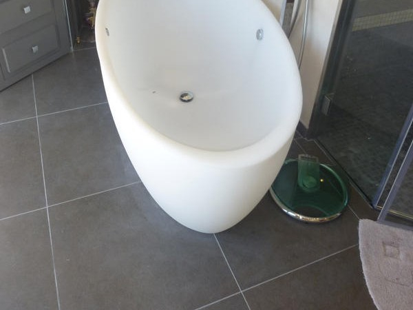 Sol en carrelage gris grand format sous une baignoire îlot, chantier Signature d'intérieur
