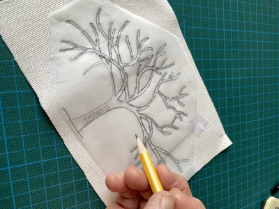 alt="dessin d'un arbre sur l'envers d'un tissu"
