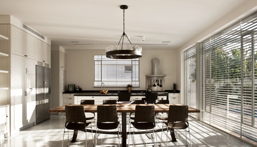 Brise-soleil orientables installés sur façade moderne avec terrasse en bois