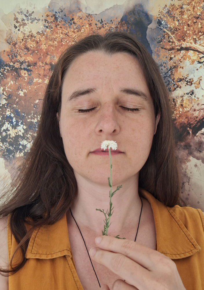 Mélanie POLLÈS qui sent une fleur de camomille noble