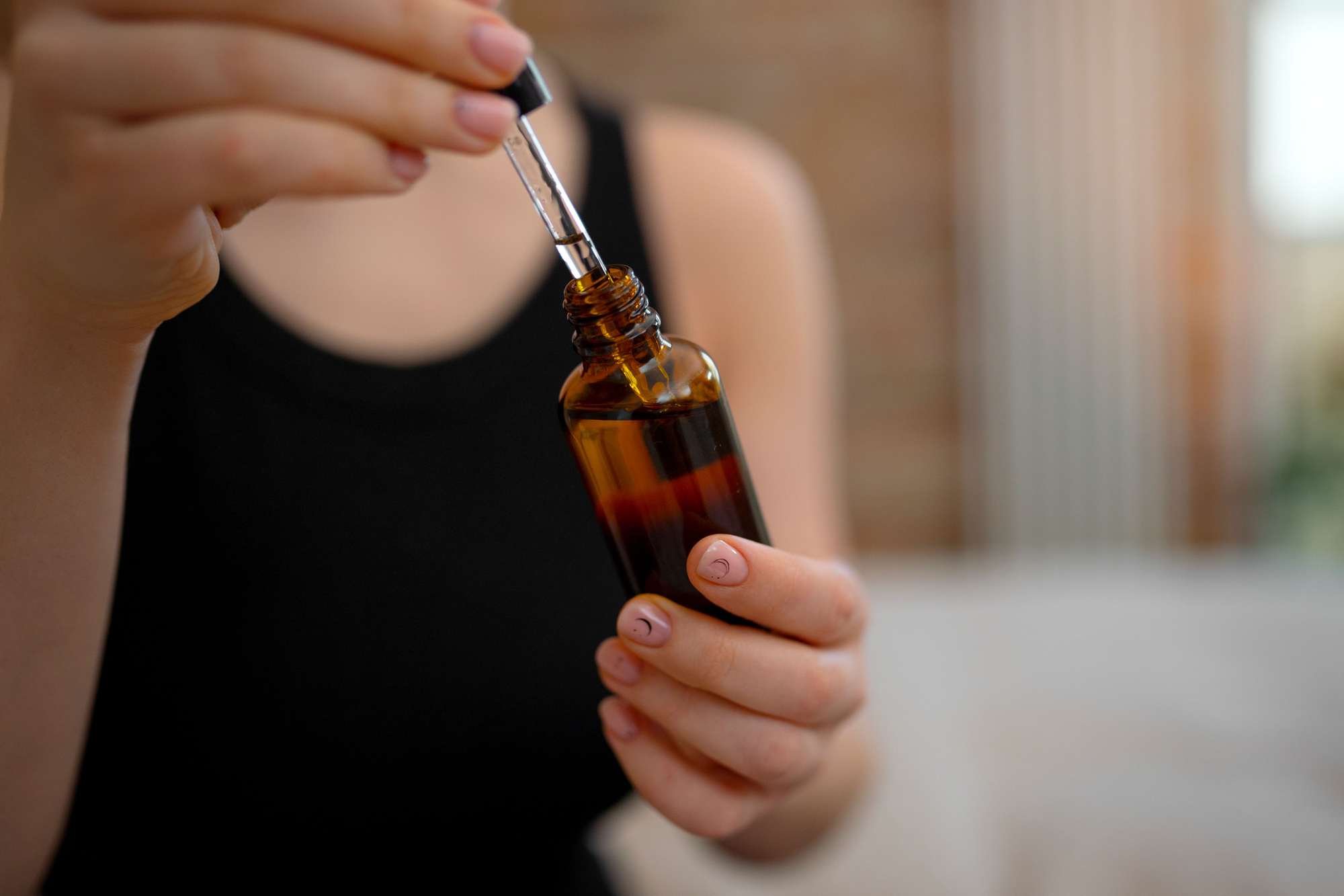 Flacon d'huile essentielle en main avec une pipette