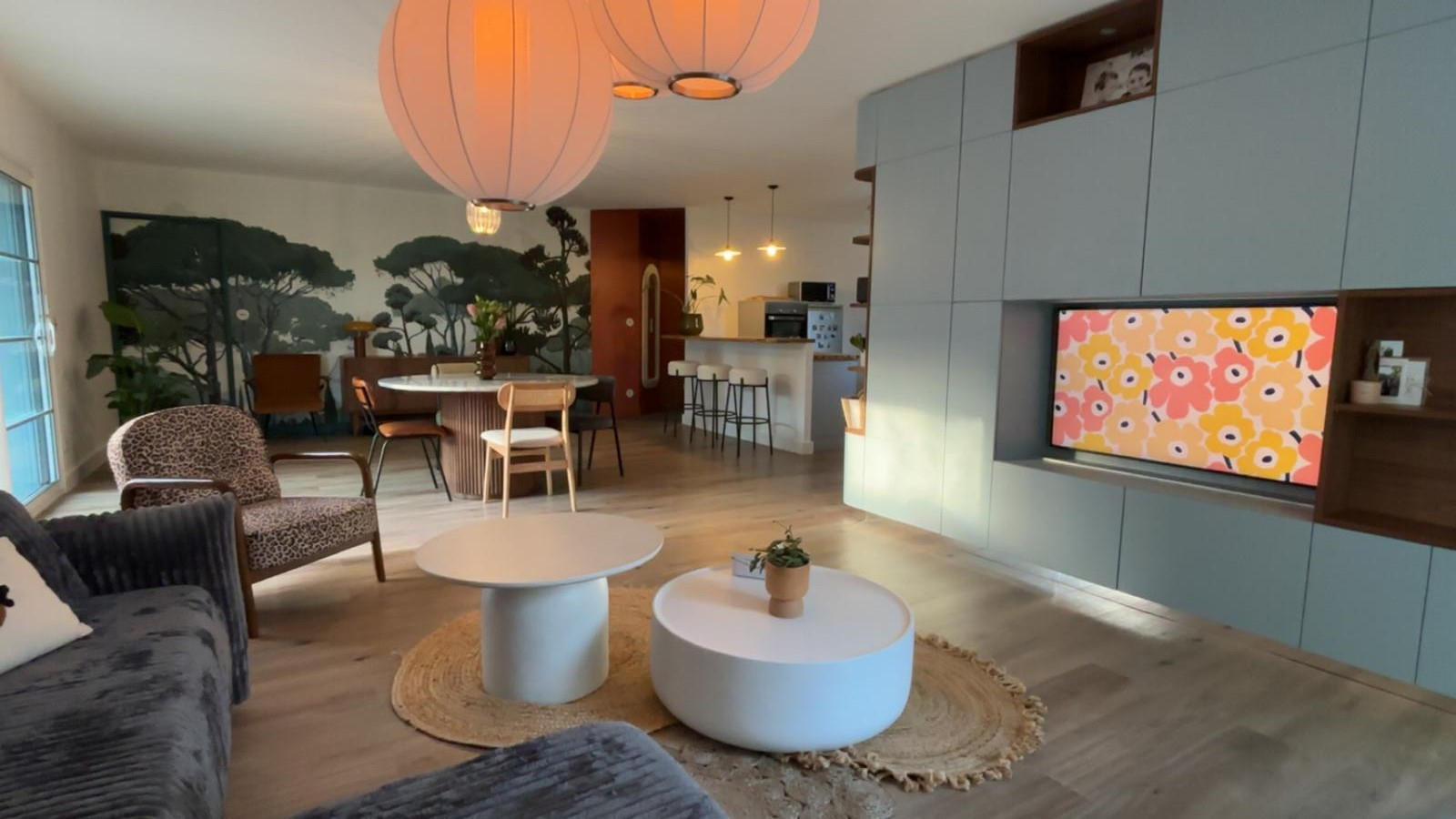 Salon rénové sur l’Île de Ré avec étagère coulissante, télé intégrée et papier peint panoramique