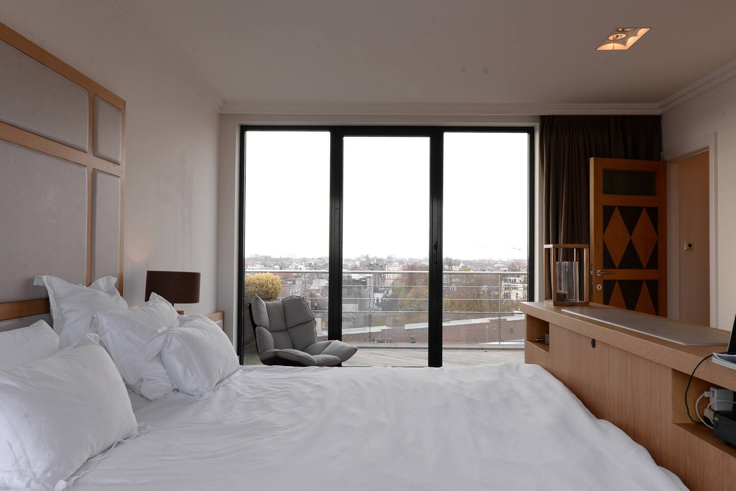 Suite principale, lit face aux baies vitrées et à la terrasse