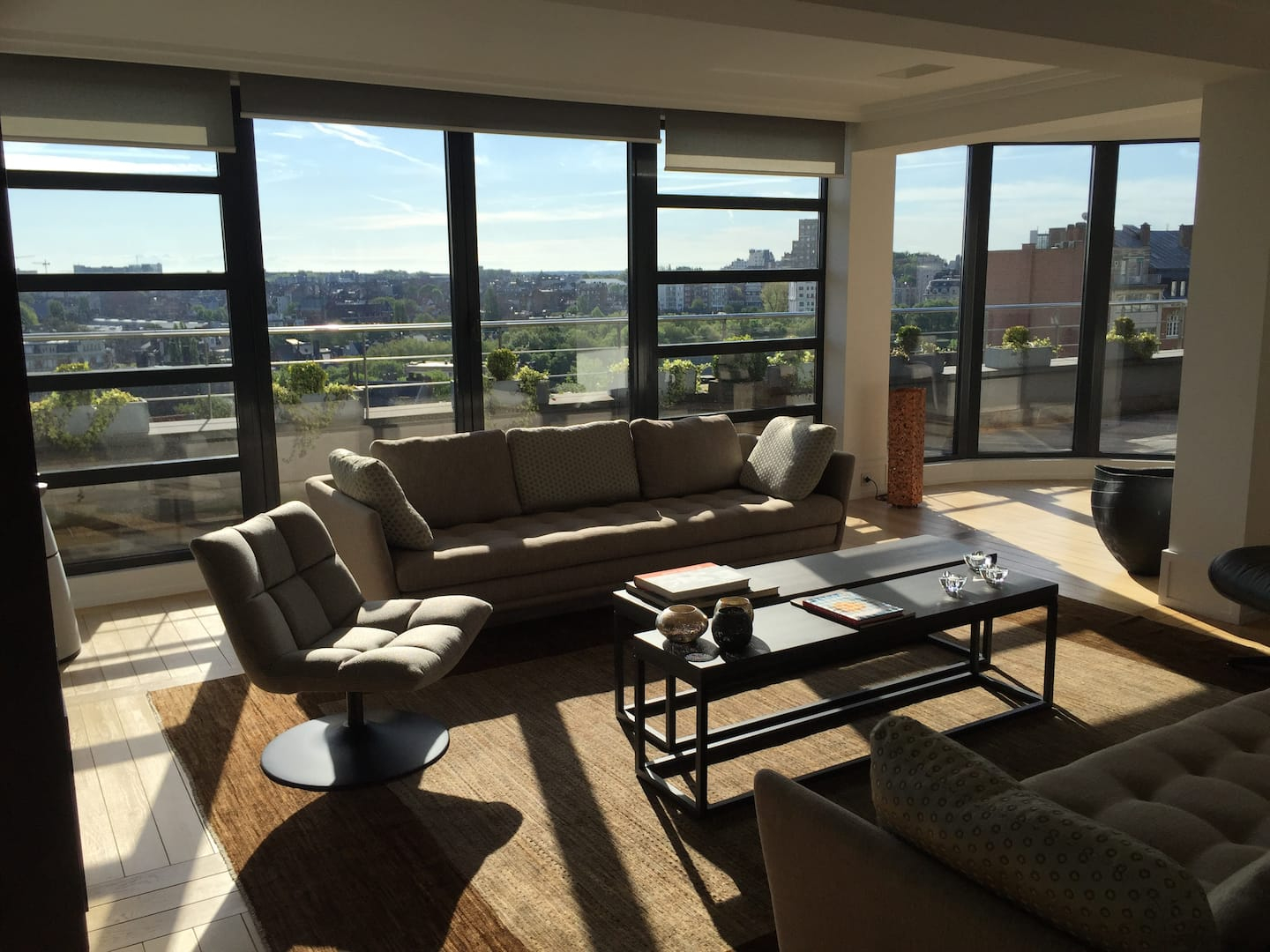 Grand salon avec baies vitrées et vue panoramique sur Bruxelles